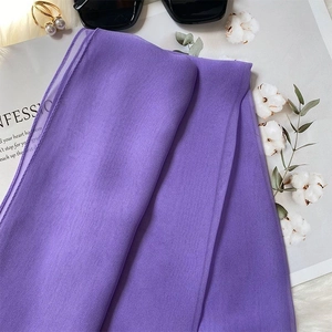 Detail of purple silk scarf with sunglasses and pearls on a magazine layout
