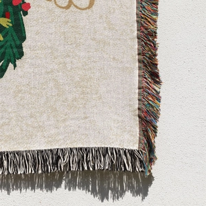 Close-up of knit Christmas tree blanket with colorful tassels and detailed weaving
