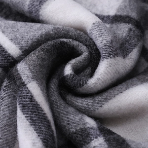 Macro detail of soft grey and white plaid wool fabric showing the premium fuzzy texture