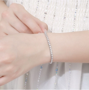 Detail of 2mm moissanite sterling silver bracelet worn on wrist with soft white fabric