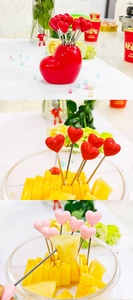 Detailed view of heart-shaped fruit forks with red and pink resin heads on metal stems