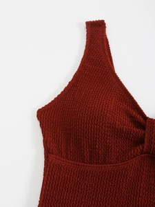 Gros plan sur la texture gaufrée rouge foncé d'un maillot de bain une pièce chic