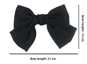 Detail of a black satin oversized bow hair clip with 21cm x 13cm dimensions shown on white background