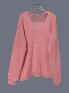 Detail showing the fluffy texture and V-neckline of a soft pink knitted sweater
