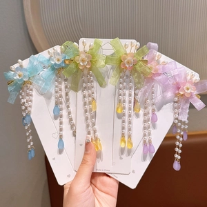 Detail of floral hair clips with silk ribbons and pearl tassels for girls in multiple colors