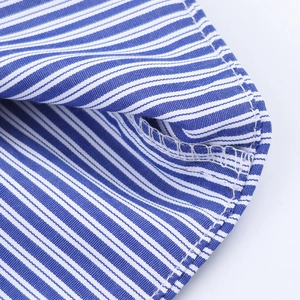 Détail du tissu à rayures bleues et blanches avec coutures précises et texture tissée
