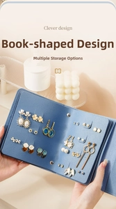 Detail of blue book-style jewelry organizer showing earring holes and internal storage layers
