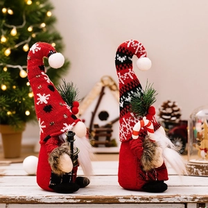Close-up of two Christmas gnomes holding lanterns and candy canes in a festive setting