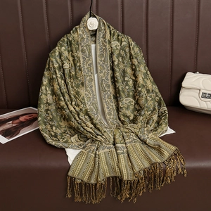 Detail of luxury olive green cashmere-style shawl with gold paisley patterns and tassels
