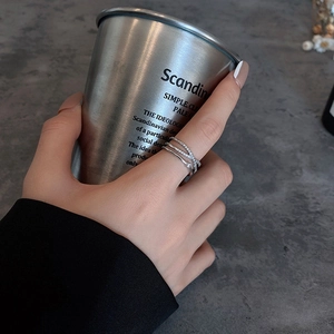 Close-up of a silver double-layer crisscross ring with zircons on a model's hand