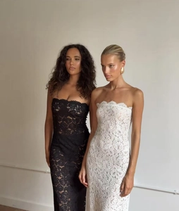 Detail van de kanten strapless jurk met opengewerkte textuur en zeemeermin-snit in zwart-wit