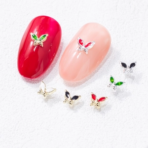 Mini butterfly nail charms with colorful enamel and metal frames on nails