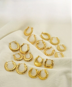 Detailed collection of 18K gold plated twisted and textured round hoop earrings on satin