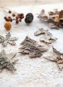Detailed view of natural birch bark Christmas ornaments arranged on artificial snow