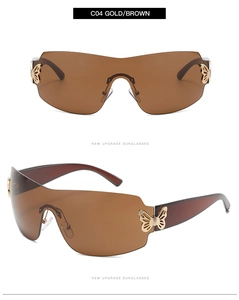 Close-up of frameless oversized sunglasses with gold butterfly hinge and brown lenses