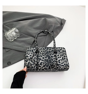 Detail of leopard print handbag with heart rivet charm and sleek single handle