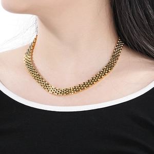Close-up of a 10mm golden watch-band style stainless steel chain necklace on a model