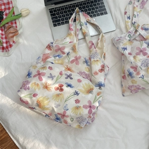 Close-up of a white mesh tote bag with colorful floral prints and large capacity