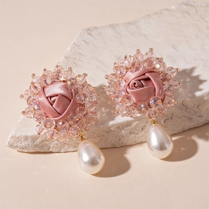 Pink fabric rose earrings with crystal beads and teardrop pearl pendants on stone