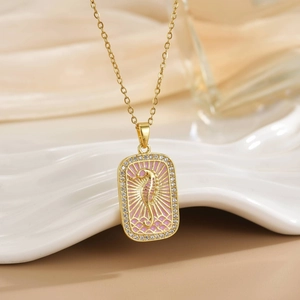 Detailed macro view of 18K gold seahorse tarot pendant with pink enamel and zircons