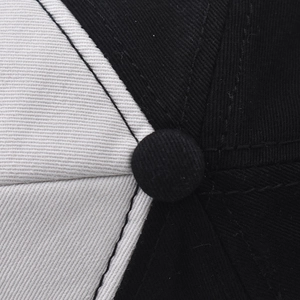 Macro view of the two-tone cotton twill fabric and reinforced top button on the baseball cap