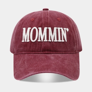 Macro detail of high-quality burgundy washed cotton baseball cap with white MOMMIN embroidery