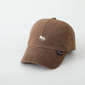 Detail of fox embroidery and brand tag on brown cotton baseball cap for kids