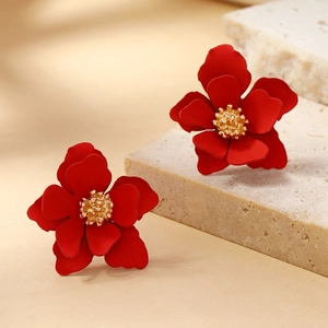 Elegant red multi-layered flower earrings with gold center on a natural stone base