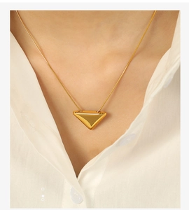 Detailed close-up of a 18k gold plated necklace with a minimalist triangle pendant