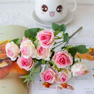 Detailed close-up of realistic pink and cream faux rose bouquet on a modern lifestyle set