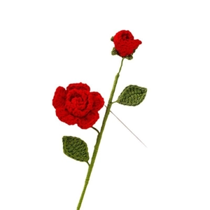 Handmade crochet red rose flower with green leaves and a metal pin on white background