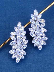 Macro shot of silver-colored leaf-shaped earrings with marquise-cut zircon stones