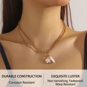 Close-up of double-layer gold chain necklace with white shell flower and pearl pendant