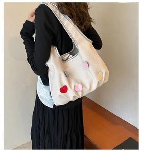 Détail du sac cabas en toile crème avec motifs de cœurs colorés et large bandoulière