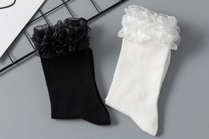 Vue à plat de chaussettes Lolita blanches et noires avec dentelle élégante et côtes