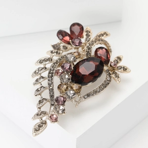 Vintage silver flower brooch with reddish-brown crystals on white geometric steps