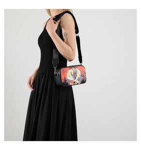 Model view of black Halloween crossbody bag with festive skull and pumpkin prints