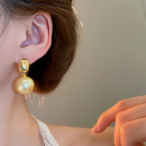 Détail de boucles d'oreilles pendantes en perles champagne plaquées or 18 carats