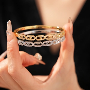 Macro detail of gold and silver plated bangle set with pavé cubic zirconia settings