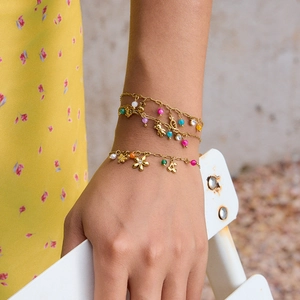 Detail of multi-layered 18K gold-plated bracelet with colorful beads and bear charms