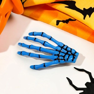 Close-up of a glossy blue skeleton hand hair clip with black detailing for Halloween