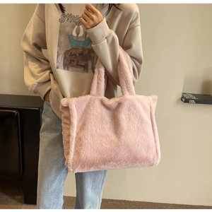 Détail montrant la texture moelleuse d'un cabas rose en peluche porté par un mannequin