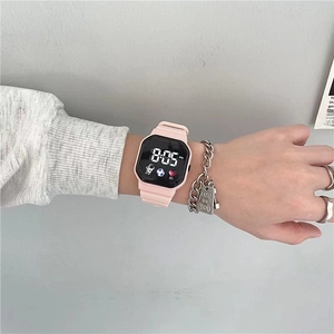 Detailed view of pink digital watch with astronaut icons on a soft silicone strap