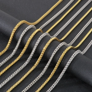Detailed view of woven punk style stainless steel chains in gold and silver finishes