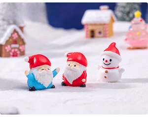 Miniature resin figurines featuring Santa Claus and snowman in a snowy winter landscape