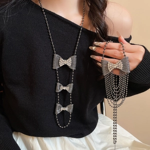 Detailed view of gunmetal bow necklace with rhinestones and elegant layered chain tassels