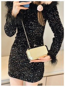 Close-up of golden geometric evening clutch bag with metal chain and sequin dress detail