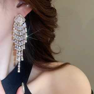 Close-up of geometric tassel earrings with gold plating and sparkling zircon stones