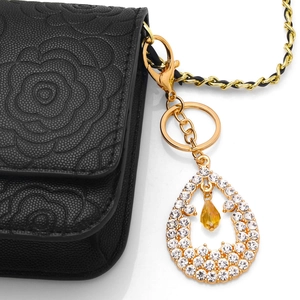 Waterdrop crystal keychain with amber gemstone on camellia embossed leather bag