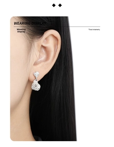Detail view of irregular lava texture silver drop earrings on model with zircon inlay